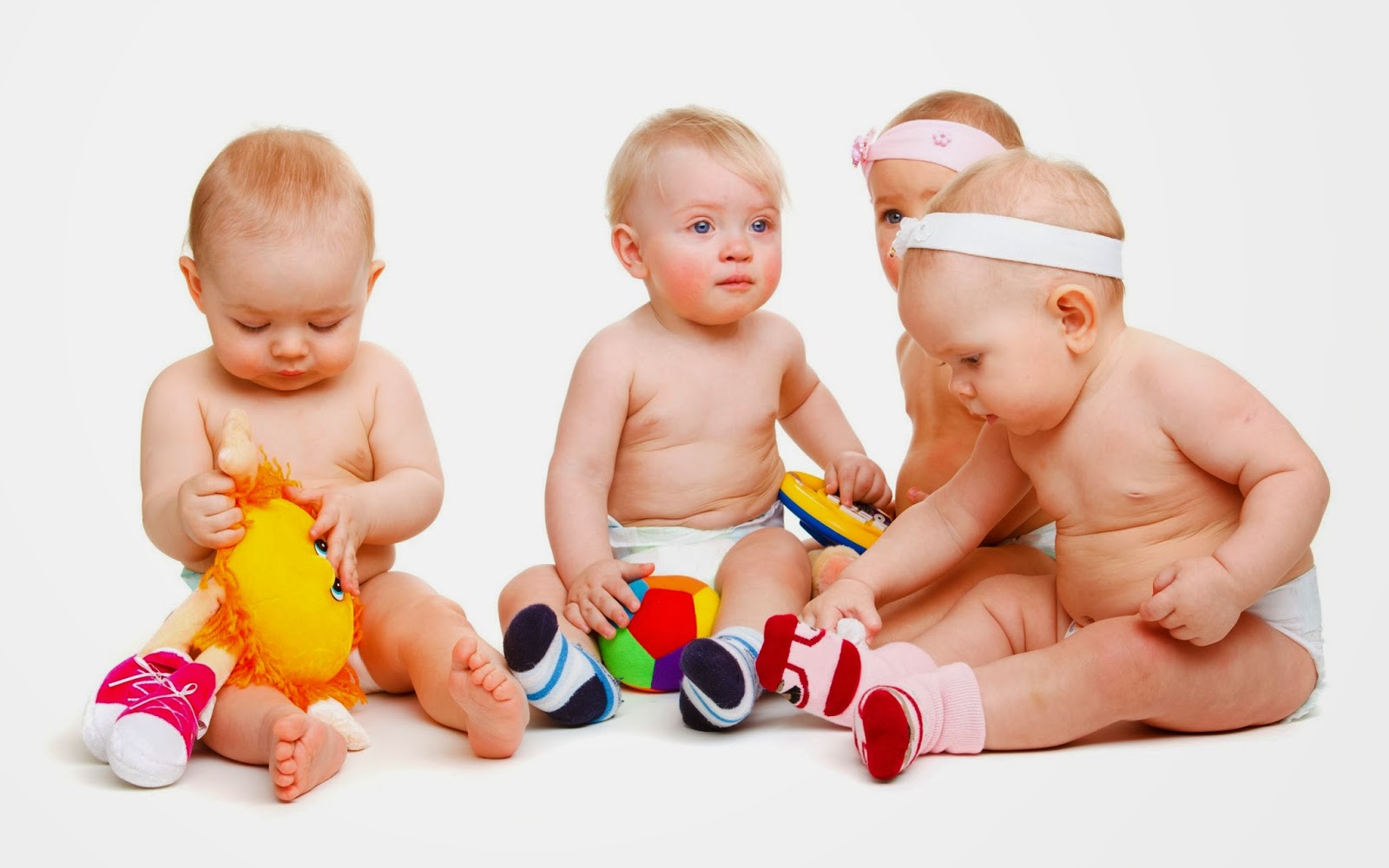 4 bebês sentados juntos brincando com brinquedos para bebês